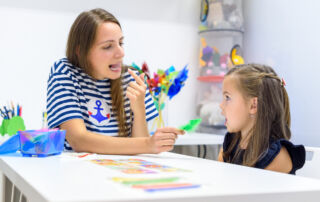 Children speech therapy concept. Preschooler practicing correct pronunciation with a female speech therapist.